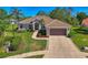Stunning single-story home with a tile roof, mature landscaping, and an attached two car garage at 7302 Dunes Ct, Bradenton, FL 34202