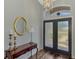 Inviting foyer with wood floors, decorative table, mirror, and views of the front door at 7302 Dunes Ct, Bradenton, FL 34202