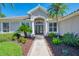 Home's inviting entrance features manicured landscaping, decorative planters, and a walkway to the front door at 7302 Dunes Ct, Bradenton, FL 34202