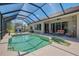 Inviting screened-in pool area with a sparkling in-ground pool, adjacent seating, and lush landscaping for privacy at 7302 Dunes Ct, Bradenton, FL 34202