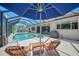 Relaxing pool and patio with wooden lounge chairs and an umbrella, perfect for outdoor enjoyment and leisure at 7302 Dunes Ct, Bradenton, FL 34202