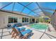 Backyard with a screened-in pool, outdoor furniture, and a well-maintained exterior, perfect for relaxation and entertainment at 7302 Dunes Ct, Bradenton, FL 34202