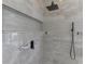 Close up of the elegant shower featuring multiple shower heads, with white marble and decorative tile accents at 7302 Dunes Ct, Bradenton, FL 34202