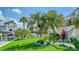 Scenic backyard with palm trees, green lawn, and canal views at 795 Marbury Ln, Longboat Key, FL 34228