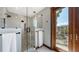 Elegant bathroom features a glass shower with black fixtures and view of a door leading to an outdoor balcony at 795 Marbury Ln, Longboat Key, FL 34228