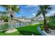 Waterfront property with boat lift, lush landscaping, artificial turf, and waterway views at 795 Marbury Ln, Longboat Key, FL 34228