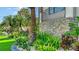 Beautiful stone exterior with tropical landscaping, palm trees, and manicured artificial grass at 795 Marbury Ln, Longboat Key, FL 34228
