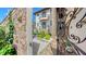 View through the iron gate showcases the home's stone exterior, balconies, and landscaped courtyard at 795 Marbury Ln, Longboat Key, FL 34228