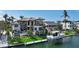 Waterfront home featuring a private dock, boat lift, pool, and manicured landscaping with mature palm trees at 795 Marbury Ln, Longboat Key, FL 34228