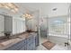 Bathroom featuring double vanity, granite countertops, large mirror, walk-in shower, and soaking tub at 8106 Arlewood Cir, Port Charlotte, FL 33981