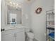 Clean half bathroom with white fixtures and a decorative wreath on the wall at 8106 Arlewood Cir, Port Charlotte, FL 33981