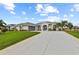 Manicured lawn, arched windows and decorative columns accentuate this home with an extended driveway and two-car garage at 8106 Arlewood Cir, Port Charlotte, FL 33981