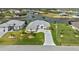 Waterfront home boasts lush lawn, mature palms, and an extended driveway leading to an attached two-car garage at 8106 Arlewood Cir, Port Charlotte, FL 33981