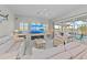 Bright living room with white sofas, ceiling fan, and view of pool and lake at 8106 Arlewood Cir, Port Charlotte, FL 33981