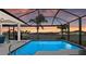 Sparkling pool with a screened enclosure offers a beautiful waterfront view during sunset at 8106 Arlewood Cir, Port Charlotte, FL 33981