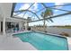 A beautiful screened-in pool with seating area and a view of the canal at 8106 Arlewood Cir, Port Charlotte, FL 33981