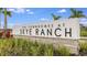Sign for The Townhomes at Skye Ranch with lush landscaping against a clear blue sky at 8689 Daybreak St, Sarasota, FL 34241