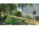 Side yard featuring partial grass, shade trees, privacy fence, and side door access at 8804 Founders Cir, Palmetto, FL 34221