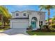 Elegant two-story home features a manicured lawn and a bright, welcoming blue front door at 8804 Founders Cir, Palmetto, FL 34221