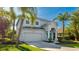 Charming two-story home with lush landscaping, mature palm trees, and a two-car garage at 8804 Founders Cir, Palmetto, FL 34221