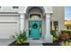 Close-up of the front door with decorative wreath, flanked by columns and lush landscaping at 8804 Founders Cir, Palmetto, FL 34221