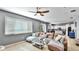 Open-concept living room featuring a large sectional couch, ceiling fan, and tile flooring that flows into the kitchen at 8804 Founders Cir, Palmetto, FL 34221