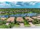Scenic aerial view of a community with homes bordering a tranquil lake and lush greenery at 8820 Heritage Sound Dr, Bradenton, FL 34212