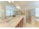 Large bathroom with double sink vanity, soaking tub, and glass-enclosed shower at 8820 Heritage Sound Dr, Bradenton, FL 34212