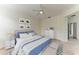 Bright bedroom featuring a ceiling fan, neutral walls, stylish decor, and a comfortable bed with blue and white accents at 8820 Heritage Sound Dr, Bradenton, FL 34212