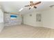 Spacious living room featuring wood-look flooring, a ceiling fan, and stone accent walls at 8820 Heritage Sound Dr, Bradenton, FL 34212