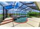 Inviting pool area featuring a spa, screened enclosure, and scenic lake views at 8820 Heritage Sound Dr, Bradenton, FL 34212