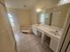 Bright bathroom featuring a double sink vanity and a soaking tub, offering a relaxing at-home spa experience at 9926 Gulfstream Blvd, Englewood, FL 34224