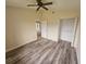 Comfortable bedroom with a ceiling fan, laminate floors, and a closet with open doors at 9926 Gulfstream Blvd, Englewood, FL 34224