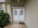 Inviting entryway with decorative glass block above double doors and tiled front porch at 9926 Gulfstream Blvd, Englewood, FL 34224