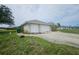Home exterior featuring a two car garage and a concrete driveway at 9926 Gulfstream Blvd, Englewood, FL 34224