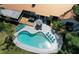 Aerial view of a backyard with a large pool, wooden deck, patio furniture, and lush landscaping at 1112 Montezuma Dr, Bradenton, FL 34209