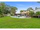 Spacious backyard with lush green lawn and a sparkling pool with lounge chairs at 1112 Montezuma Dr, Bradenton, FL 34209