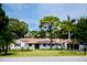 Charming single-story home with a metal roof, lush landscaping, and a well-maintained front yard at 1112 Montezuma Dr, Bradenton, FL 34209