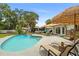 Backyard pool with tropical landscaping, lounge chairs, and tiki umbrellas at 1112 Montezuma Dr, Bradenton, FL 34209