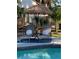 Relaxing poolside lounge area featuring comfortable lounge chairs, a tiki umbrella, and privacy landscaping at 1112 Montezuma Dr, Bradenton, FL 34209