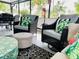 A covered porch with comfortable chairs, colorful pillows, tropical plants, and a unique center table at 1112 Montezuma Dr, Bradenton, FL 34209