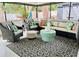 A covered porch with comfortable chairs, pillows, and a unique center table at 1112 Montezuma Dr, Bradenton, FL 34209