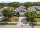Aerial view of a well-maintained single-Gathering home featuring lush landscaping and a brick paved driveway at 11434 Spring Gate Trl, Bradenton, FL 34211
