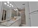Bathroom featuring double sinks, granite countertops, a large mirror, and a walk-in shower at 11434 Spring Gate Trl, Bradenton, FL 34211