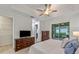 Relaxing bedroom featuring neutral walls, an outdoor patio and a dresser with mounted television at 11434 Spring Gate Trl, Bradenton, FL 34211