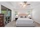 Bright bedroom with a ceiling fan, neutral decor, and a sliding glass door leading to the outside at 11434 Spring Gate Trl, Bradenton, FL 34211