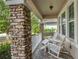 Cozy front porch featuring stone columns, white railings, and comfortable seating at 11434 Spring Gate Trl, Bradenton, FL 34211