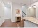 Hallway with hardwood floors, a mirrored cabinet, and view of the staircase and kitchen island at 11434 Spring Gate Trl, Bradenton, FL 34211