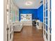 Bright home office with hardwood floors, blue accent wall, white shelving, and a workspace at 11434 Spring Gate Trl, Bradenton, FL 34211