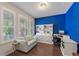Bright home office with hardwood floors, blue accent wall, white shelving, and a workspace at 11434 Spring Gate Trl, Bradenton, FL 34211